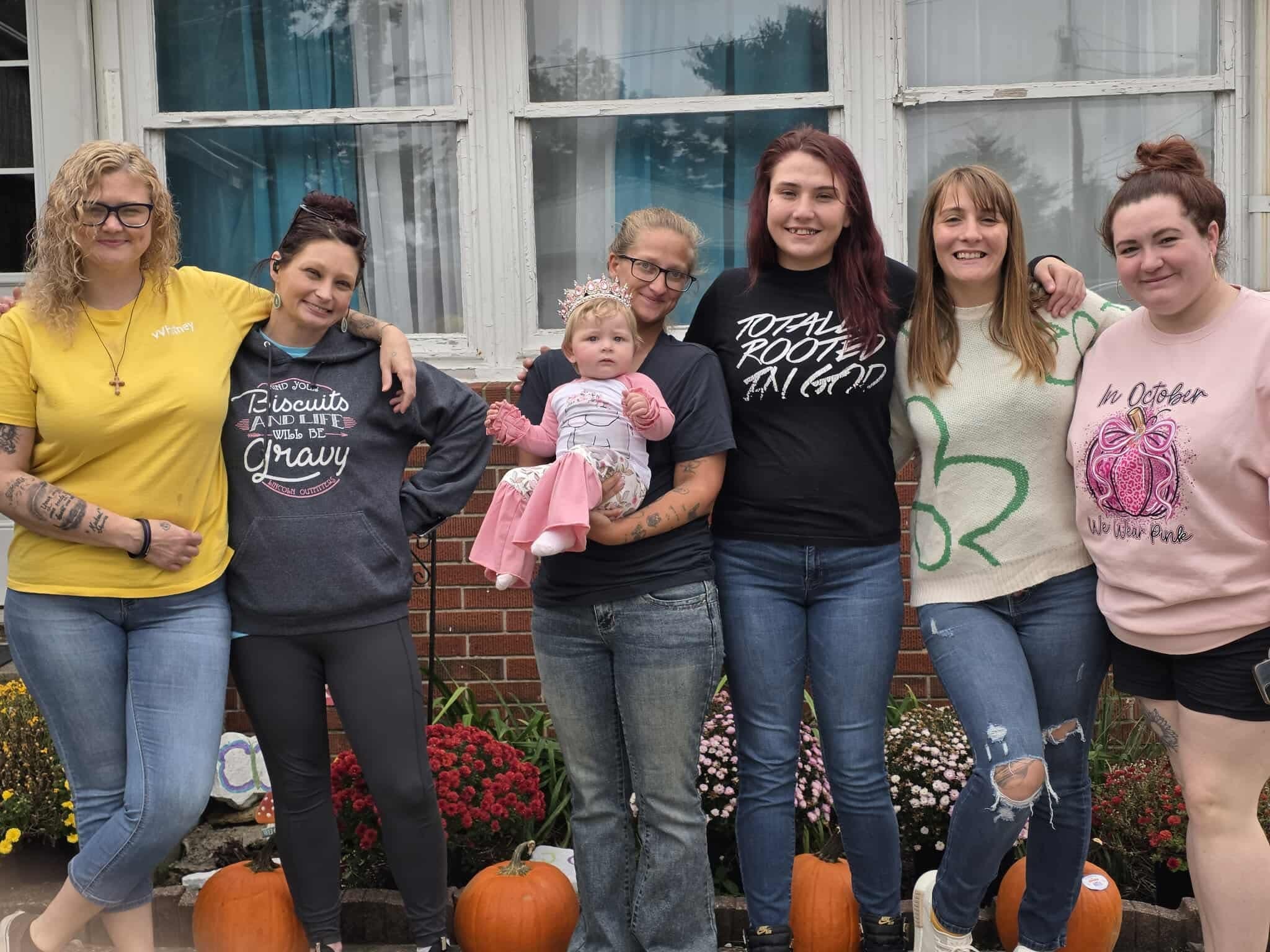 Gift House residents and staff posing outside the home with pumpkins in the fall