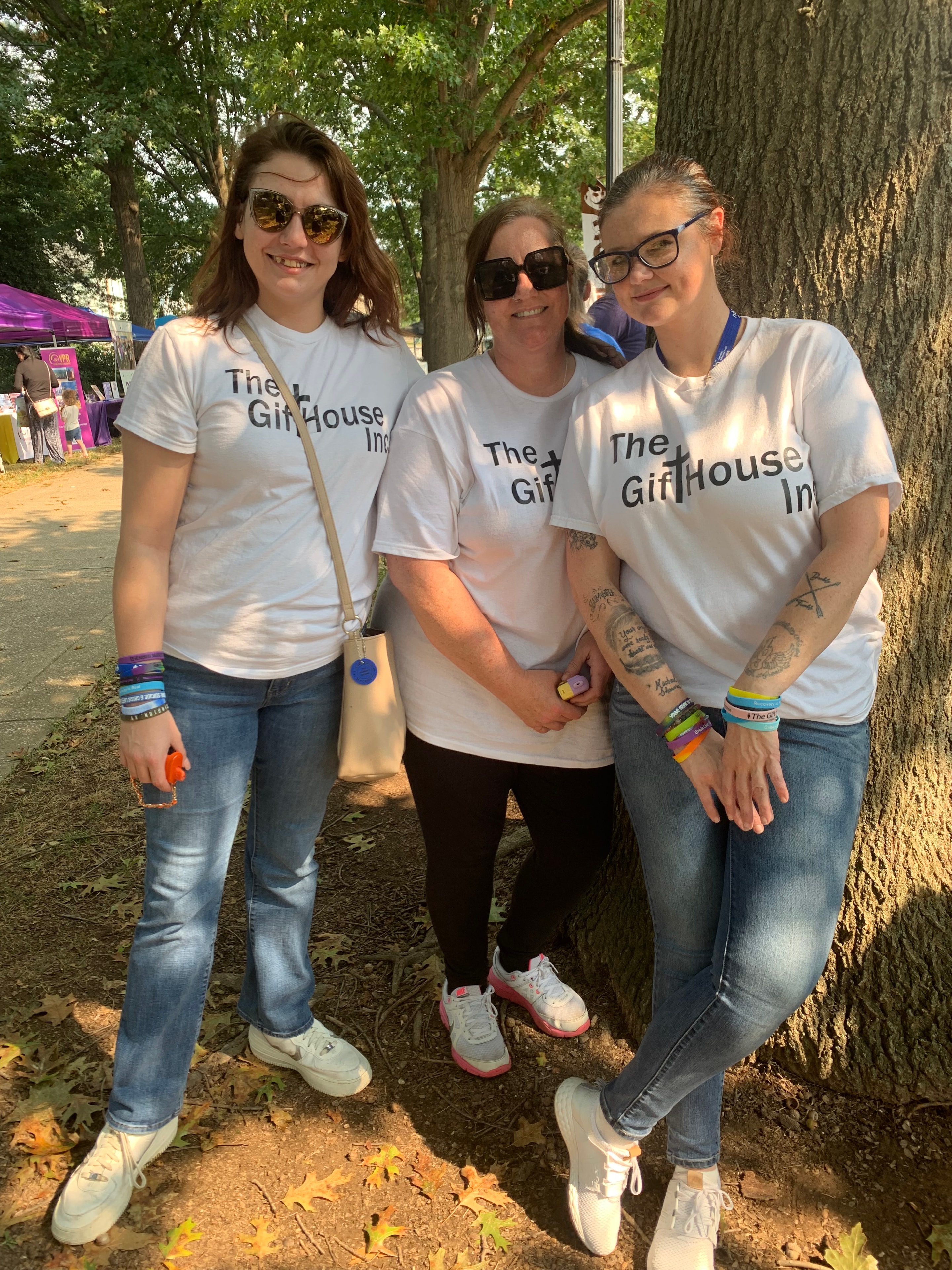 Three Gift House women in branded t-shirts at a community event